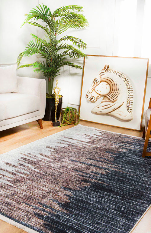 Load image 1 in gallery view. A modern living room features a beige sofa, leafy potted plant, decorative trophy, and large framed horse head artwork on the floor. The wooden floor is covered by the Pixelated Paradise - Machine-Washable Rug JR902 in bronze and brown.