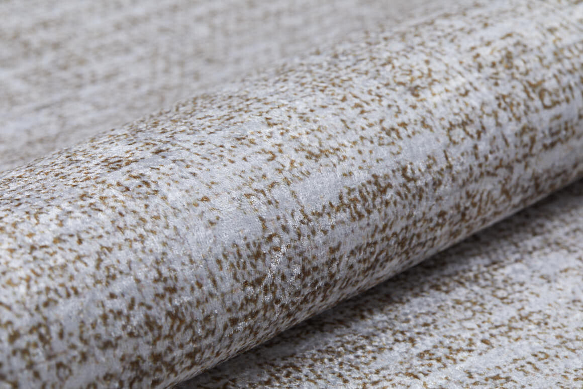 A close-up of Pure Bliss - Washable Rug - JR745 (Outlet) US shows a textured weave with light gray and brown speckles. The soft, washable material is slightly reflective, making it ideal for high-traffic areas and stylish interiors.