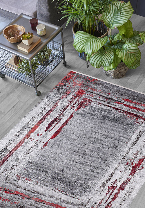 Load image 1 in gallery view. A modern living room with a potted plant, metal side table, and the Refined and Timeless - Washable Rug - JR1500 in gray, white, and red abstract patterns—ideal for high-traffic or allergy-sensitive spaces on a light wood floor.