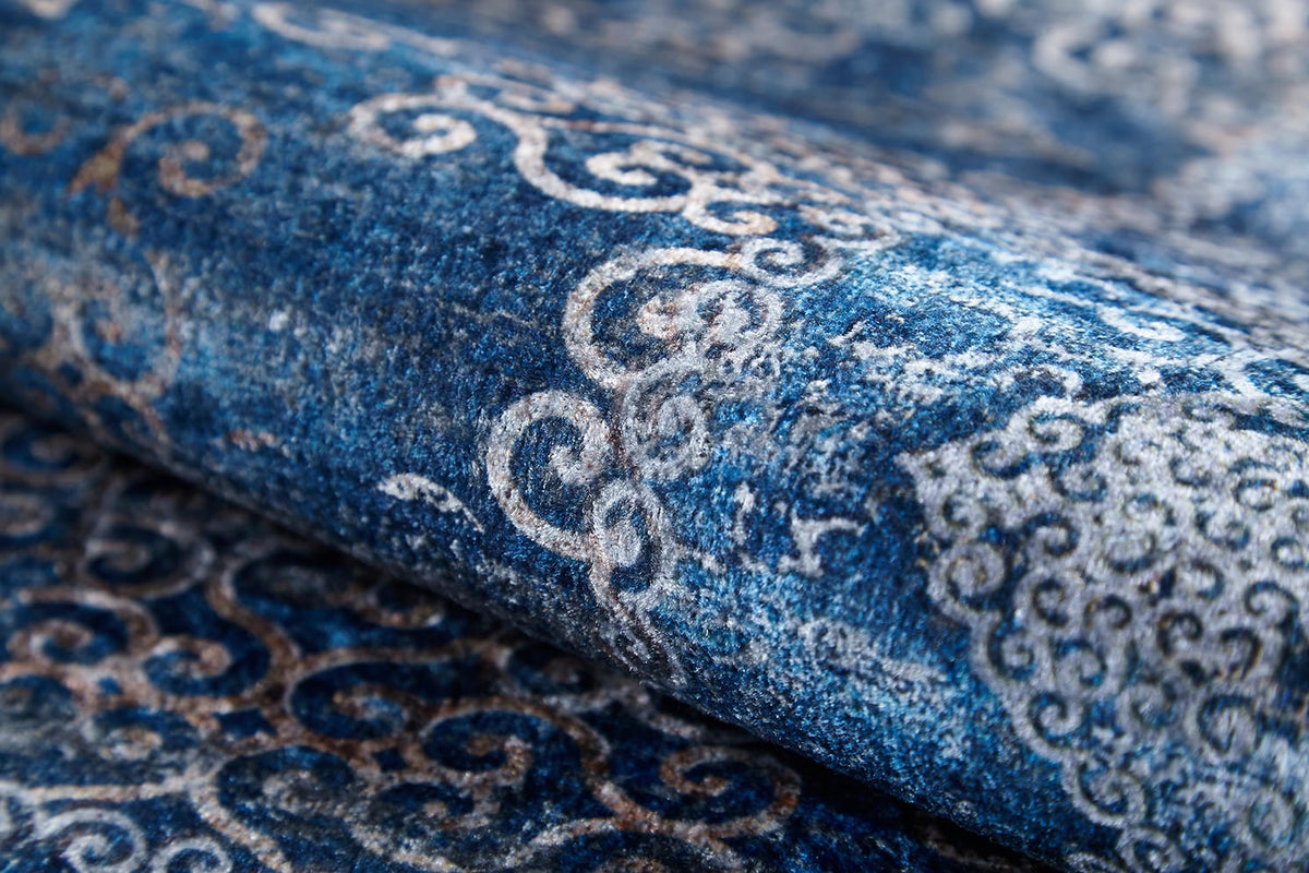 A close-up of the Regal Insignia - Washable Rug - JR1786 reveals rich texture and detailed blue, white, and beige swirling patterns—an ideal choice for high-traffic areas.