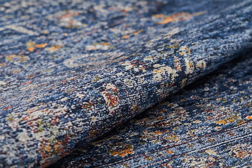 Load image 1 in gallery view. A close-up of the Regal Splendor - Washable Rug - JR1017 in blue with orange, yellow, and cream accents shows its textured surface and slightly folded edge—ideal for high-traffic spaces.