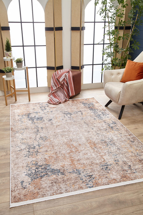 Load image 1 in gallery view. A cozy living room with the modern Rhythmic Ripples - Washable Rug - JR1637 in cream and beige, a white armchair with an orange cushion, a potted plant, side table with small plants, and large arched windows filling the space with light.