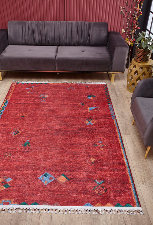 Load image 1 in gallery view. A living room featuring the Rosy Blush - Machine-Washable Rug - JRS5067, perfect for high-traffic areas, gray velvet sofas, a wooden side table with a plant, pink panel walls, light wood floors, and bright natural light.