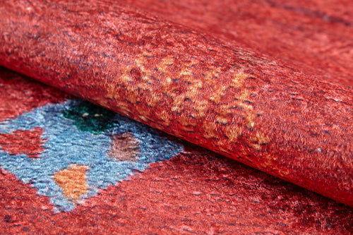 Load image 1 in gallery view. A close-up of the Rosy Blush - Machine-Washable Rug (JRS5067), featuring a red, textured surface with rolled edges, blue and orange geometric patterns, and subtle yellow accents—ideal for high-traffic areas.