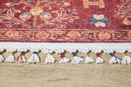 Load image 1 in gallery view. Close-up of the Rustic Retreat - Washable Rug (JR5095) in red, featuring decorative white fringe and colorful threads on a light wood floor—ideal for high-traffic areas and easy to wash.