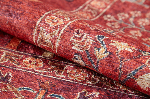 Load image 1 in gallery view. Close-up of the Rustic Retreat - Washable Rug - JR5095, featuring intricate floral and geometric designs with detailed weaving. Partially folded to showcase its thickness, this rug is perfect for high-traffic areas and easy to clean.