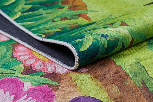 Load image 1 in gallery view. Close-up of the Safari Buddies - Machine-Washable Rug JRC041, featuring a colorful floral pattern with green leaves and pink and purple flowers, detailed edge stitching, and a glimpse of the underside—ideal for high-traffic areas.