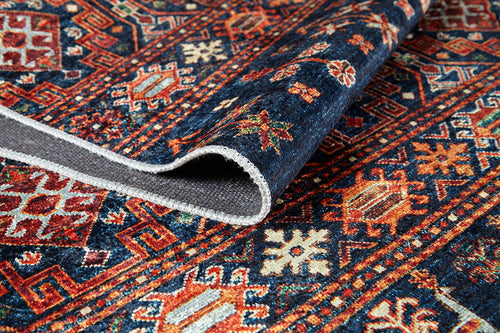 Bild 1 in Galerieansicht laden. A close-up of the Sahara Sunrise - Washable Rug - JR5091, featuring blue, orange, red, and cream geometric and floral designs. Partially folded to show texture and underside; ideal for high-traffic areas while adding vibrant style.
