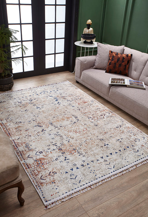 Load image 1 in gallery view. A cozy living room featuring the Shangri-La - Washable Rug - JR5042 in cream and beige, a beige couch with a geometric pillow, a round table, potted plant, and large black-framed windows—ideal for allergy-sensitive homes.