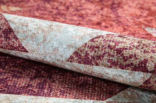 Bild 1 in Galerieansicht laden. A close-up of the Simplistic Artistry - Washable Rug - JR1647 shows its geometric pattern in red, burgundy, and beige. The soft, durable texture stands out when folded—ideal for high-traffic areas.