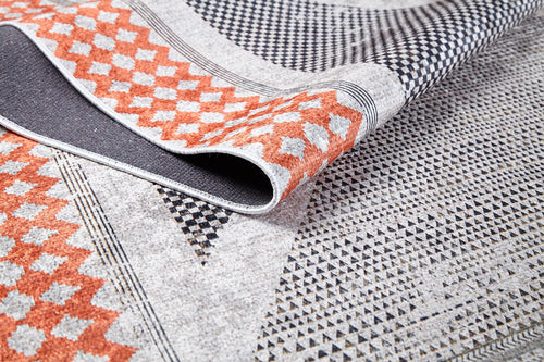 Load image 1 in gallery view. A close-up of the Sleek Design - Washable Rug - JR1727 shows orange and black geometric patterns on a light background with a folded corner revealing its texture—perfect for allergy-sensitive, high-traffic areas.