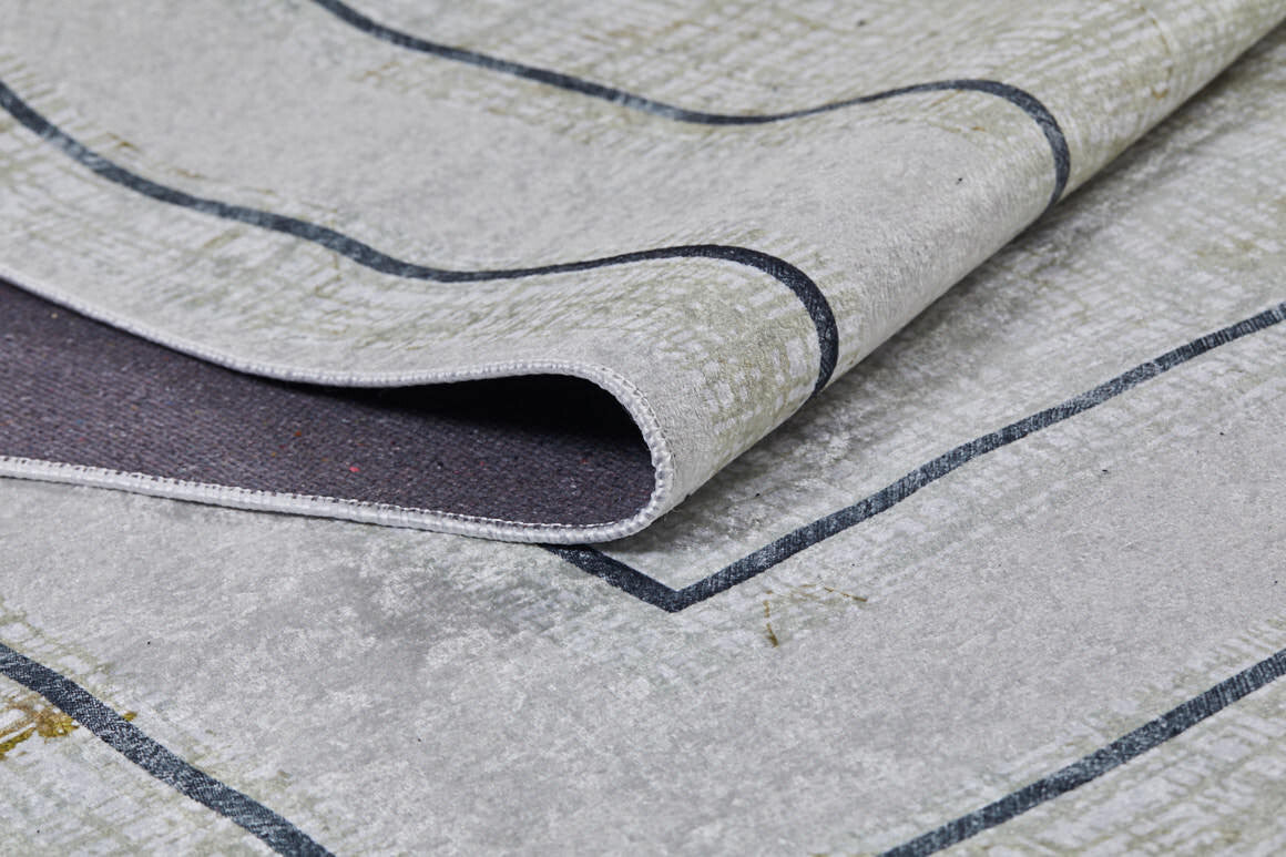 A close-up of the Sleek and Contemporary - Washable Rug - JR1365 in gray with dark geometric lines; its folded corner reveals texture and thickness—perfect for allergy-sensitive homes.