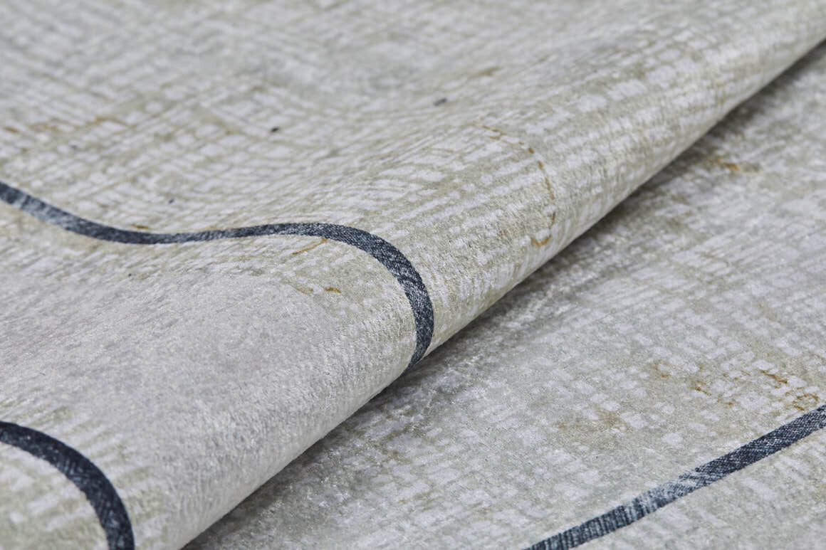 A close-up of the Sleek and Contemporary - Washable Rug - JR1365 shows its light gray textured fabric with a subtle grid pattern and dark curved line—ideal for allergy-sensitive homes wanting a clean, modern look.