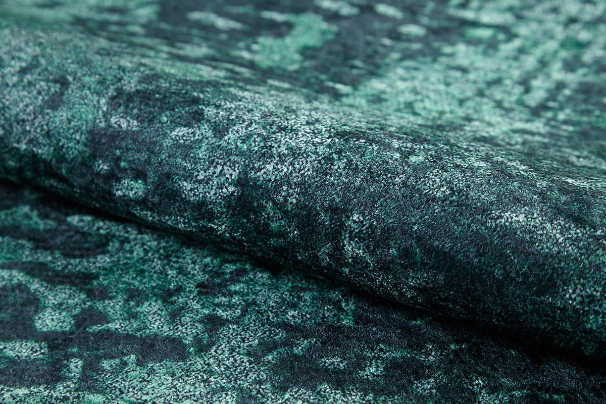 Close-up of Smokey Mountains - Washable Rug - JR1631, featuring folded green and black textured fabric with a mottled, abstract pattern and a soft, velvety feel—perfect for high-traffic areas.