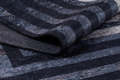 Load image 1 in gallery view. A close-up of the Sophisticated and Chic - Washable Rug - JR1409, featuring a soft, plush surface with textured horizontal and diagonal stripes in varying shades of dark gray, blue, and black.