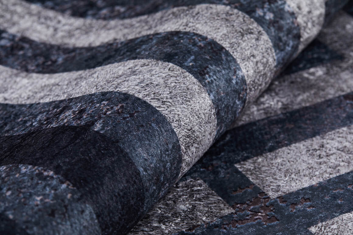 A close-up of the Sophisticated and Chic - Washable Rug - JR1409 shows its soft, slightly raised surface with textured, wavy horizontal stripes in various shades of gray and black.