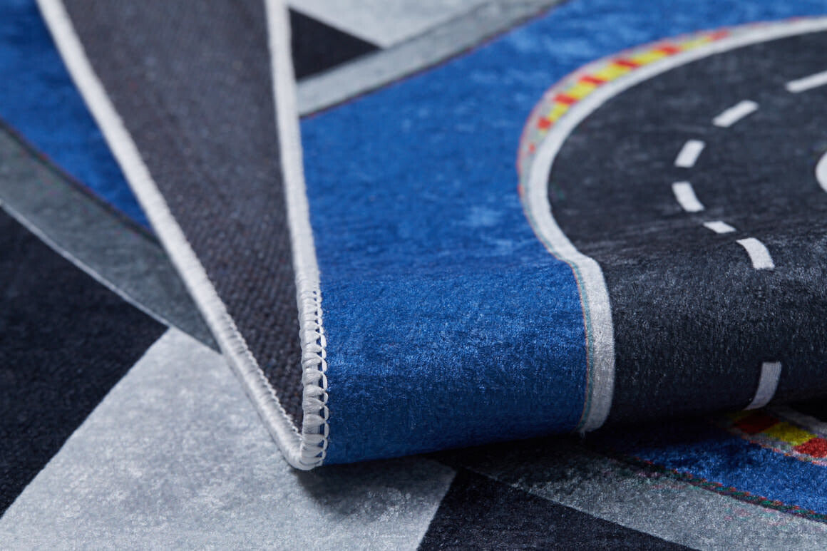 Close-up of the Speedway Sprouts - Machine-Washable Rug JRC068, a folded play mat with a colorful curved road, blue and gray sections, and stitched edging—ideal for high-traffic areas.