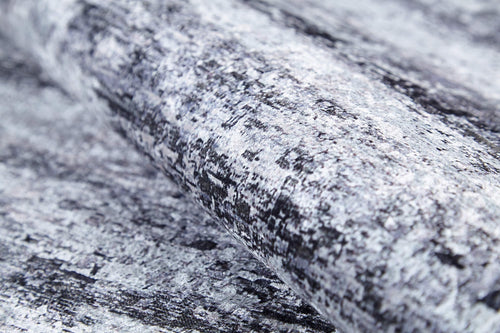 Bild 1 in Galerieansicht laden. A close-up of a roll of textured wallpaper in mottled gray, black, and white—resembling stone or brushstrokes—pairs perfectly with the Stone Path - Washable Rug - JR1772 for a coordinated look in high-traffic areas.