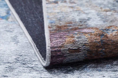Load image 1 in gallery view. A close-up of the Striking Statements - Washable Rug - JR786, showing its multicolor flat weave, textured surface, and stitched edge partially folded on a light speckled background.
