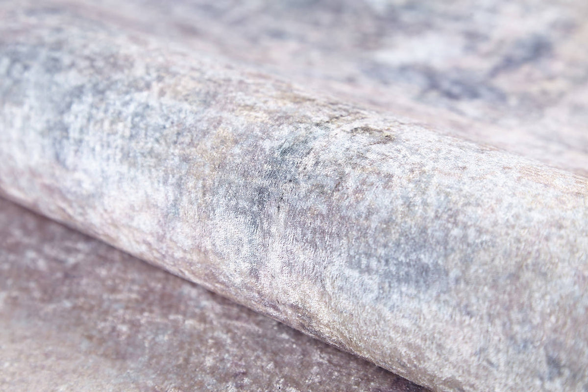 A close-up of the Sunset Sky Ombre - Washable Rug (JR1918) shows its soft, velvety textured light grey and beige surface with a subtle metallic sheen—ideal for high-traffic areas and easy to clean.