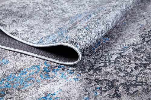 Load image 1 in gallery view. A close-up of the Timeless Embellishment - Washable Rug (JR1943) in gray and blue shows its textured flat weave surface, intricate patterns, and a folded corner.