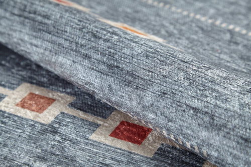 Load image 1 in gallery view. Close-up of the Tuscan Villa - Washable Rug - JR5058: a textured gray-anthracite rug with red and beige diamond patterns linked by beige lines. Partially folded to show its plush, thick surface—ideal for high-traffic spaces.