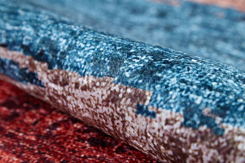 Load image 1 in gallery view. A close-up of the Urban Edge - Washable Rug - JR2005, showing its soft, thick texture and woven fibers in vibrant blue, brown, and red shades with a multicolor pattern.