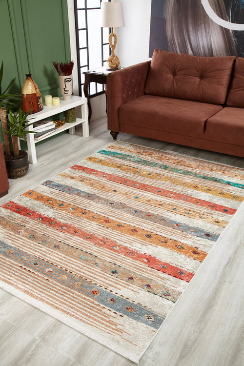 Load image 1 in gallery view. A living room with a brown sofa, green wall, side table with decor, and the Nomad's Nostalgia - Washable Rug - JR1669 showcasing multicolor subtle patterns on a light wood floor—ideal for high-traffic areas and easy care.