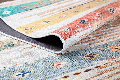 Load image 1 in gallery view. A close-up of the Nomad's Nostalgia - Washable Rug (JR1669) shows vibrant stripes and geometric shapes, with a folded corner revealing its dark underside—ideal for brightening high-traffic spaces.