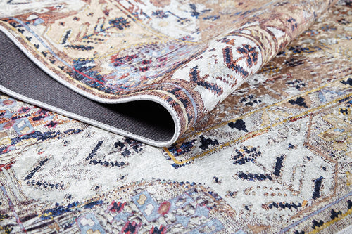 Load image 1 in gallery view. A close-up of Native Nature's Washable Rug - JR1666 (Outlet) US shows one corner folded, revealing intricate geometric and floral patterns in beige, cream, blue, red, and yellow.