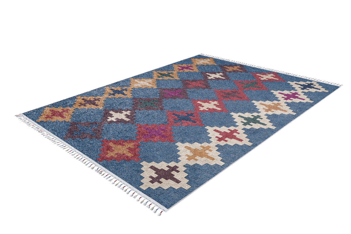 The Nomad's Mirage - Washable Rug - JR5032 is a rectangular blue-base rug with a grid of red, white, yellow, and purple geometric patterns and short white fringe on both ends. It’s ideal for high-traffic areas.
