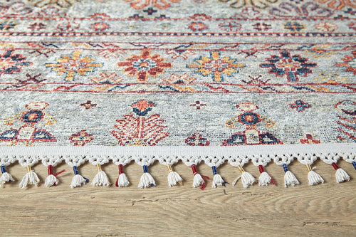Load image 1 in gallery view. The Nomad's Nest - Washable Rug - JR5088 features floral and geometric patterns in red, blue, yellow, and orange with cream fringe tassels. Shown on a wooden floor, it's perfect for high-traffic areas and easy to clean.